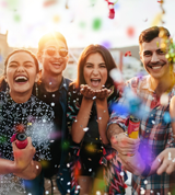 a group of people throwing confetti and smiling